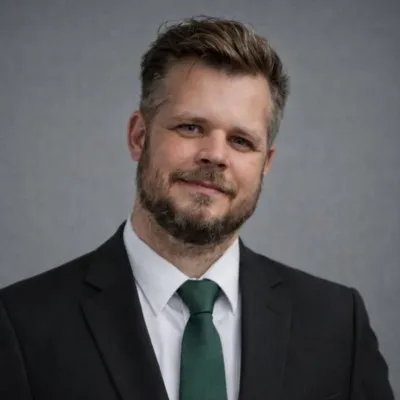 Tom Whitton, owner of Social Construct Consulting, in a dark suit and green tie
